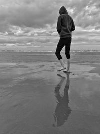 Rear view of girl standing at beach