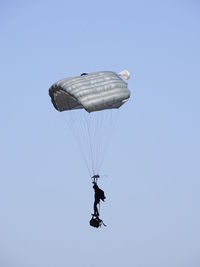 Low angle view of person paragliding against clear sky