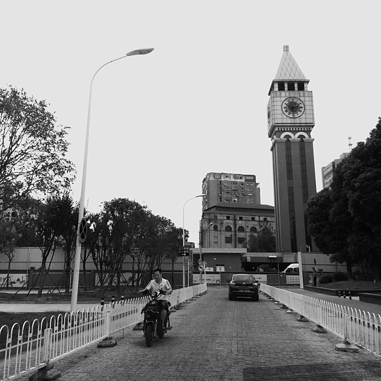 architecture, built structure, transportation, clear sky, tower, full length, lifestyles, rear view, leisure activity, building exterior, cycling, clock tower, tall - high, day, tall, casual clothing, outdoors, person, long