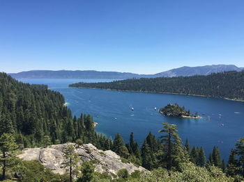 Scenic view of lake and mountains against clear blue sky