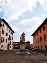 Low angle view of statue against buildings in city against sky