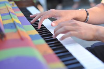 Cropped hands of person playing piano