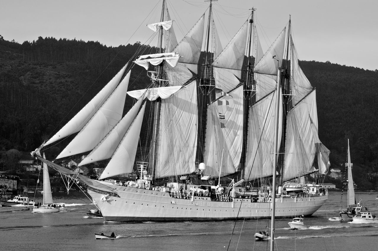 nautical vessel, transportation, mode of transport, boat, moored, mast, sailboat, water, sea, harbor, travel, rope, clear sky, sky, day, outdoors, fishing boat, no people, flag, nature