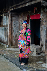 Portrait of woman standing against built structure