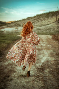Redhead woman running in the countryside