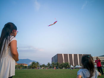 People flying kite against sky