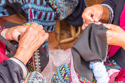 Midsection of women sewing textile