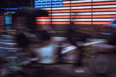 Blurred motion of people walking on street in city