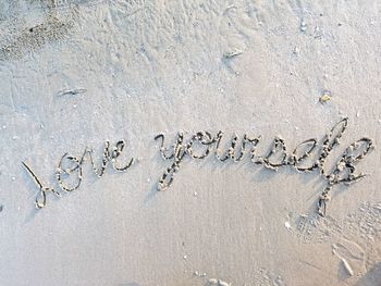 High angle view of text on sand at beach