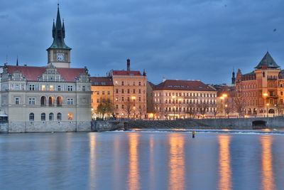 Illuminated buildings against sky in city at dusk