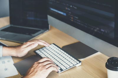 Midsection of man using laptop on table