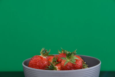 Close-up of strawberries in bowl against blue background