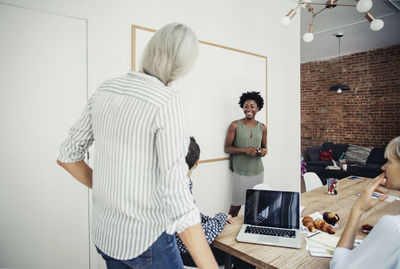 Happy businesswoman giving presentation to colleagues in board room