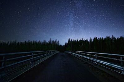 Railroad tracks against clear sky at night