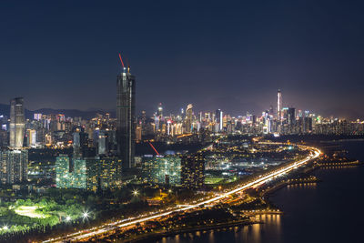 Illuminated buildings in city against sky at night