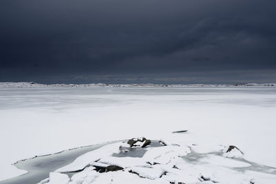 Scenic view of snow covered land against sky