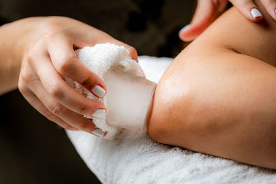 Ice massage for painful elbow. hands of a therapist placing ice directly onto a painful elbow 