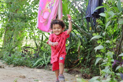 Portrait of a smiling girl standing against plants