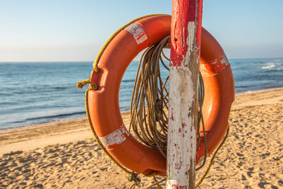 Close-up of umbrella on beach against sky