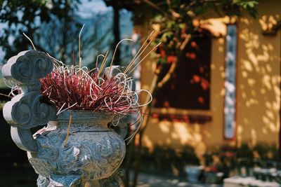 Incense sticks in urn against temple