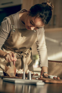 Moment of concentration in kitchen, showcasing step-by-step process involved in  decorated cupcakes