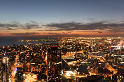 High angle view of illuminated cityscape against sky at night