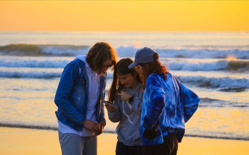 Rear view of women standing on beach