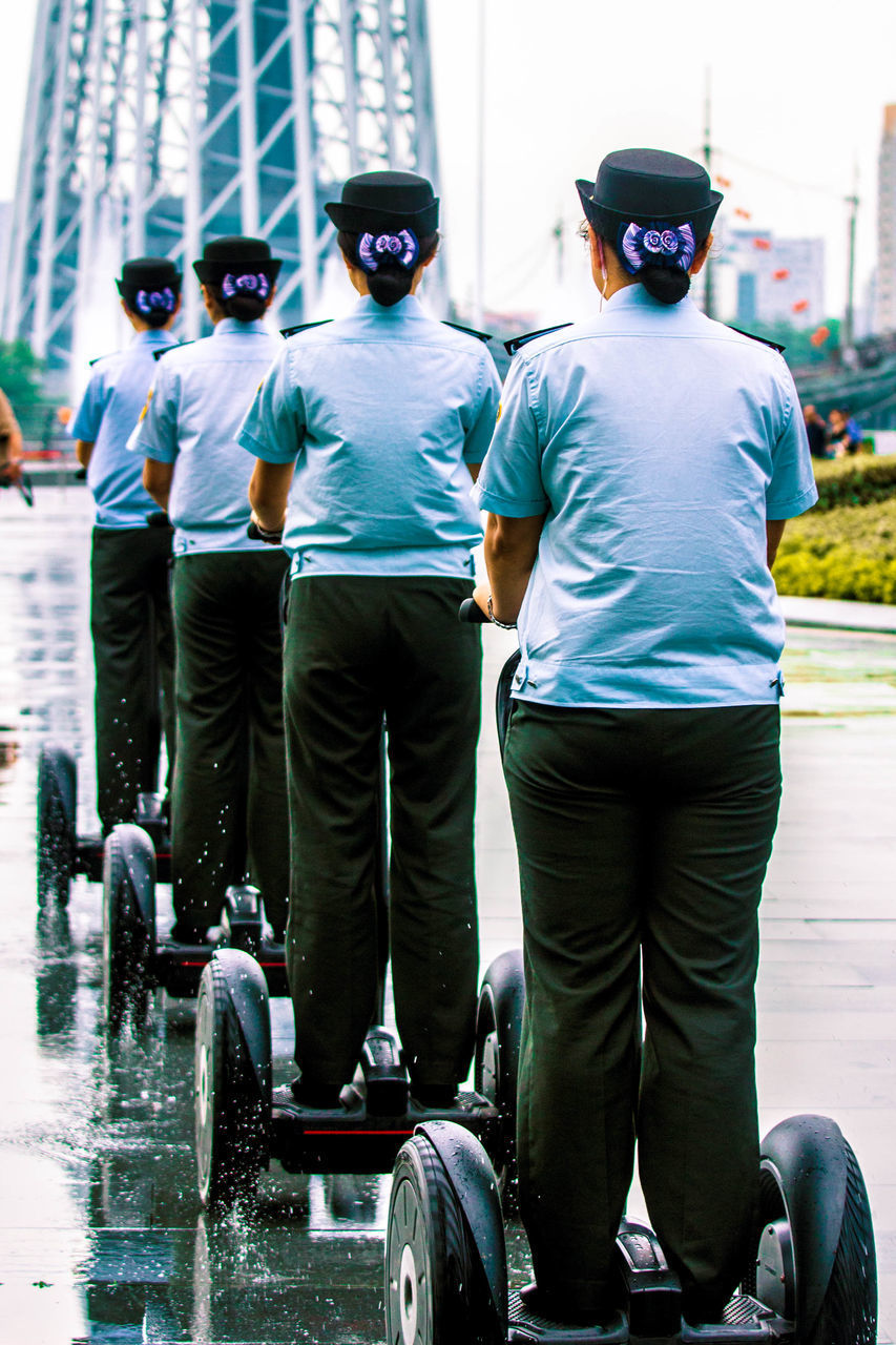 REAR VIEW OF MEN STANDING ON STREET