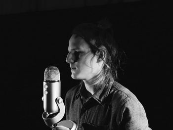 Close-up of man singing in darkroom