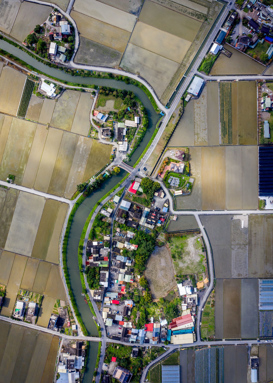 HIGH ANGLE VIEW OF CARS ON ROAD BY BUILDINGS