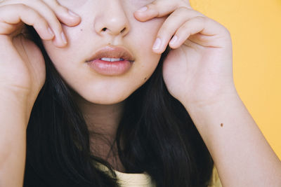 Midsection of girl against yellow background