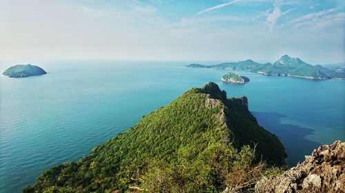 Scenic view of mountains by sea against cloudy sky