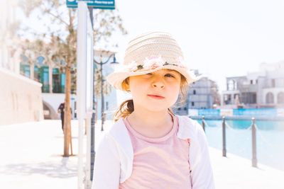 Portrait of cute girl wearing sun hat in city