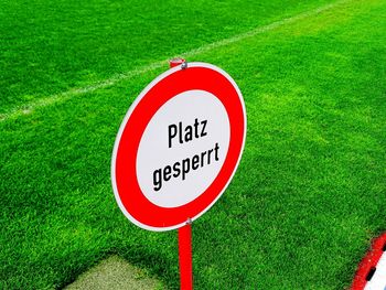 High angle view of sign board with text on grassy field at soccer field