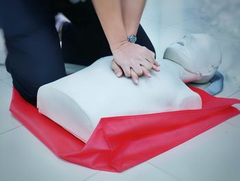 Midsection of person with cpr dummy during training