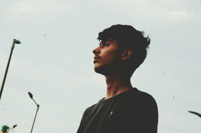 Young man standing against sky