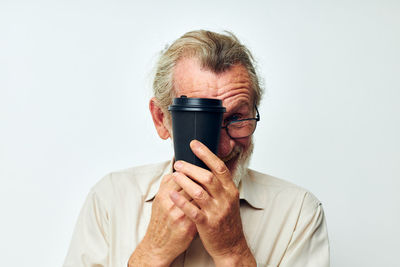 Portrait of woman photographing against white background