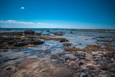 Scenic view of beach against blue sky