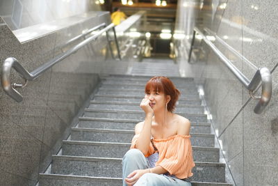 High angle view of woman sitting on staircase