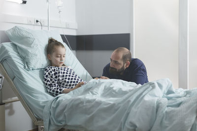 Father talking with daughter in hospital