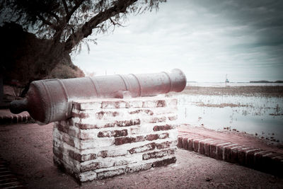 Old ruin by river against sky