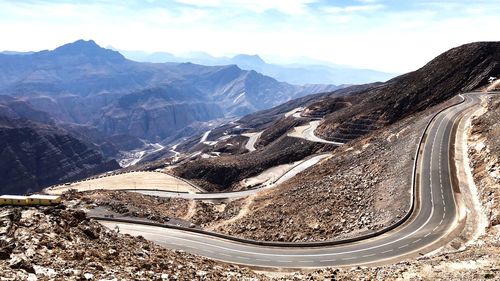 Aerial view of mountain road against cloudy sky