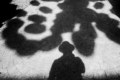 Low section of child shadow on tiled floor