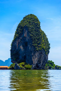 Rock formation in sea against sky