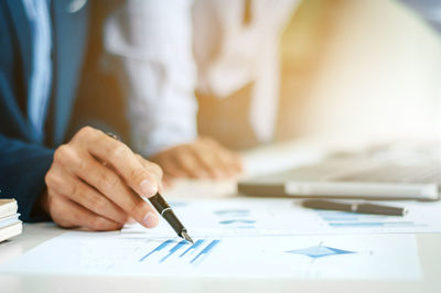 Midsection of man holding paper