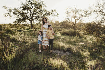 Portrait of beautiful mother and young children in sunny field