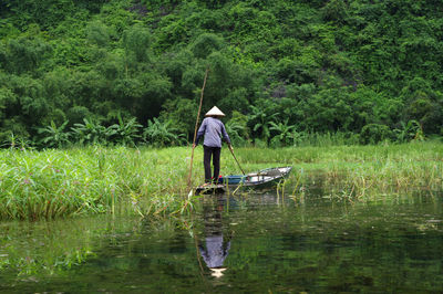 Rear view of man fishing in lake