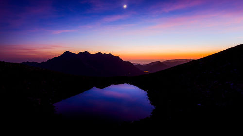 Scenic view of silhouette mountains against sky during sunset