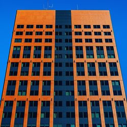 Low angle view of modern building against clear blue sky