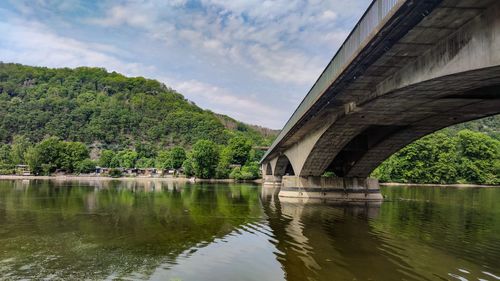 Arch bridge over river against sky